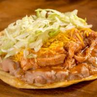 Chicken Tostada · Refried beans, shredded chicken in red sauce, cheese, and lettuce.