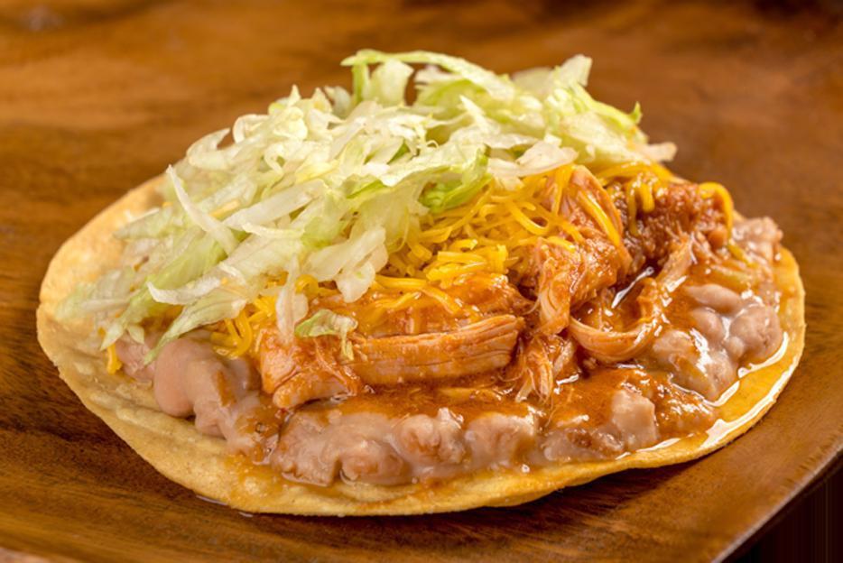 Chicken Tostada · Refried beans, shredded chicken in red sauce, cheese, and lettuce.
