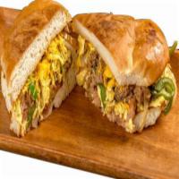 Machaca Torta · Egg, shredded beef, onion, bell pepper, tomato, refried beans, and cheese.