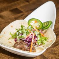 Galbi Taco · Premium short rib beef marinated in traditional galbi sauce with fresh ginger cabbage slow. ...