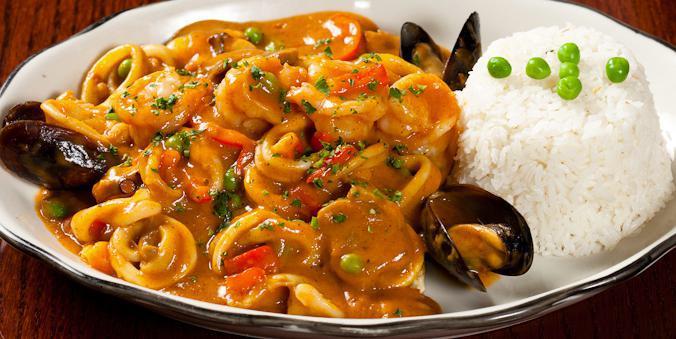 Pescado con Mariscos · A seafood combination of grilled fish filet, mussels, calamari, octopus, and shrimp in a tasty seafood bechamel sauce with mushrooms.