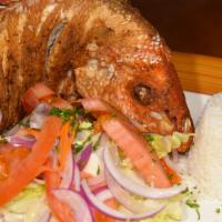Fried Whole Snapper · Pargo frito fried whole snapper served with a salad and white rice.