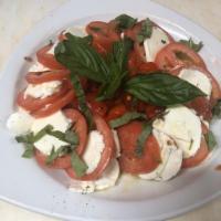 Caprese Salad · Plum tomatoes and sliced wedges of fresh mozzarella cheese topped with a basil & olive oil g...