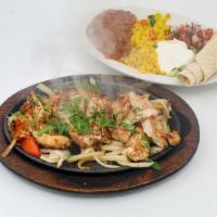 Chicken Fajitas · Delicious chicken fajita, marinated and grilled, and served with rice and beans.