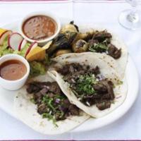 Tacos De Arrachera · Three tacos with our marinated and grilled hanger steak, garnished with onions and cilantro,...
