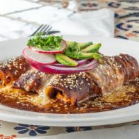 Enchiladas De Mole Poblano · Three chicken enchiladas smothered in our signature artisanal-homemade Mole Poblano sauce, c...
