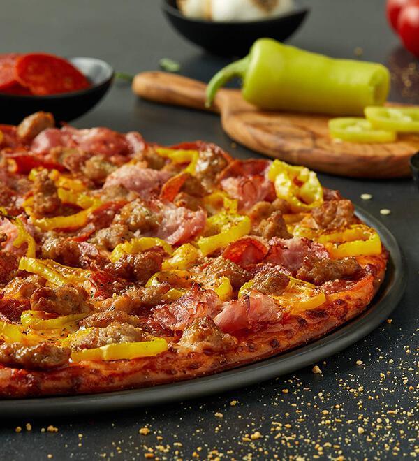 Founder's Favorite Pizza · Heritage pepperoni, family recipe sausage, shaved ham and banana peppers. Served with real Wisconsin naturally smoked provolone cheese.