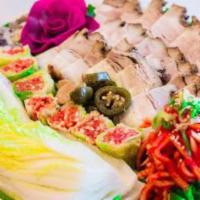 Jae Yuk Bossam · Slices of seasoned pork belly with daikon radish kimchi, pickled garlic and jalapeno. Served...