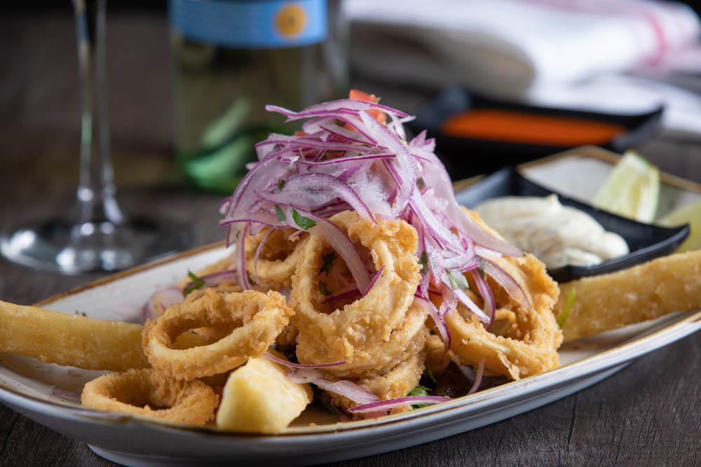 'Chicharrones' · Fried calamari rings or fish served with fried cassava, tartar sauce and 'criolla' sauce.