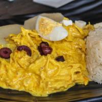 'Ají de Gallina' · Juicy shredded chicken breasts in yellow pepper cream sauce on top of sliced potatoes, black...