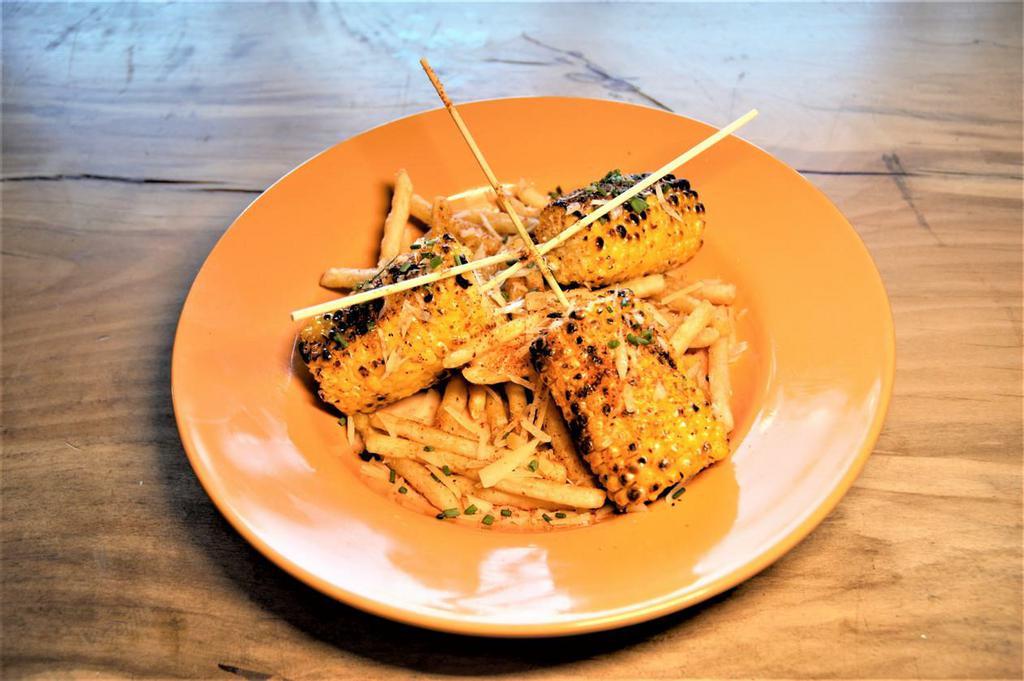 STREET CORN · ROASTED CORN COBS, SERVED ON A BED OF FRIES TOPPED WITH BEURRE BLANC, COTIJA CHEESE, TAJIN, AND CHIVES