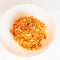 Tagliatelle alla Bolognese · Thin, ribbon-shaped housemade pasta, beef & pork ragù, Mutti tomato sauce, Parmigiano Reggia...