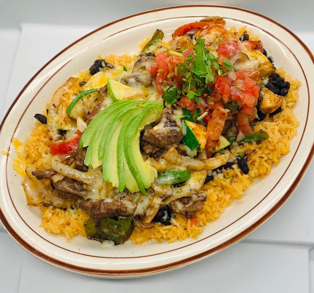 Steak Carnaval · Grilled shredded steak, grilled onions, bell peppers, squash, and mushrooms on a bed of rice and black beans. Served with pico de gallo and avocado slices.