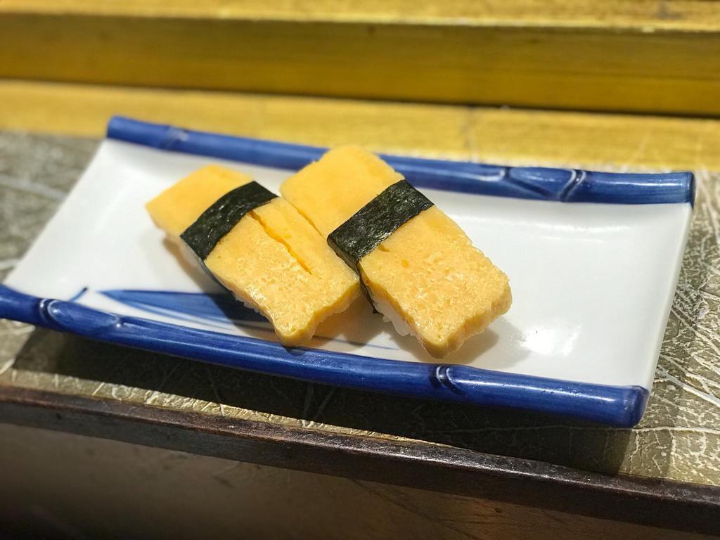 Tamago Nigiri (2 PCS) · Tamago sushi is made with the rolled egg omelet (tamagoyaki) and seasoned sushi rice. It's usually rolled into a nigiri or sushi maki rolls. When Japanese people refer to Tamagoyaki, they typically mean “rolled egg” or “rolled omelette”, though there are a few variations of tamagoyaki.