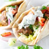 Gyro  ·  Sliced beef and lamb with tzatziki sauce, lettuce, tomato and onions on a pita bread. Tzatz...