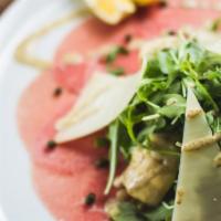 Beef Carpaccio · Thinly sliced beef garnished with mixed greens and fresh Parmesan cheese.