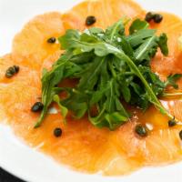 Salmon Carpaccio · Thinly sliced fresh salmon topped with fennel and arugula in a lemon olive oil dressing.