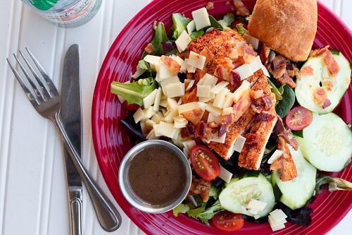 Roasted Chicken Salad · Mixed greens topped with sliced roasted chicken breast, white cheddar, bacon, cucumber and tomato and choice of dressing. Served with yeast roll.