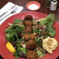 Falafel Salad  · 6 falafel patties (ground chickpeas and spices), a scoop of hummus, on top of Babajoon's sty...