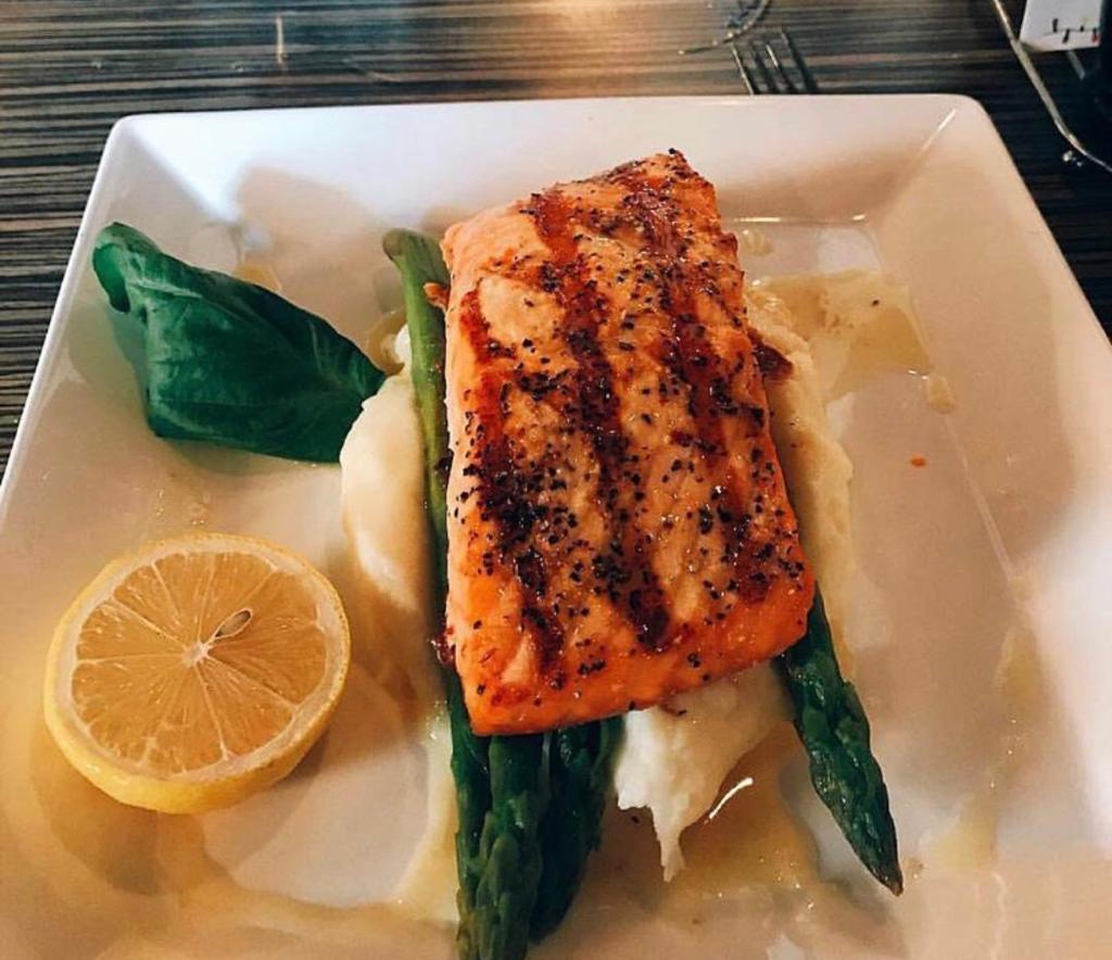 Salmon ala Roma · Grilled salmon in lemon butter wine sauce, served with grilled asparagus and mashed potatoes.