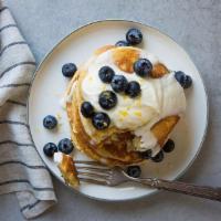 Blueberry Ricotta Lemon · Stack of Three Blueberry Pancakes, Topped With Ricotta Whipped Cream, Bursting with Fresh Bl...