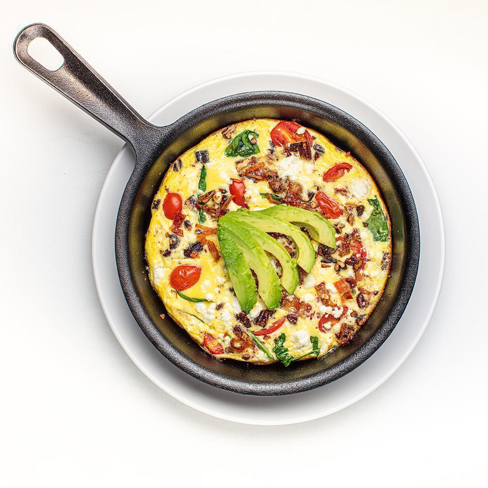 California Skillet · Baked in Oven Mixture of Eggs, Spinach, Pecan-Rosemary Bacon, Cherry Tomatoes and Goat Cheese, Garnished with Avocado Wedges