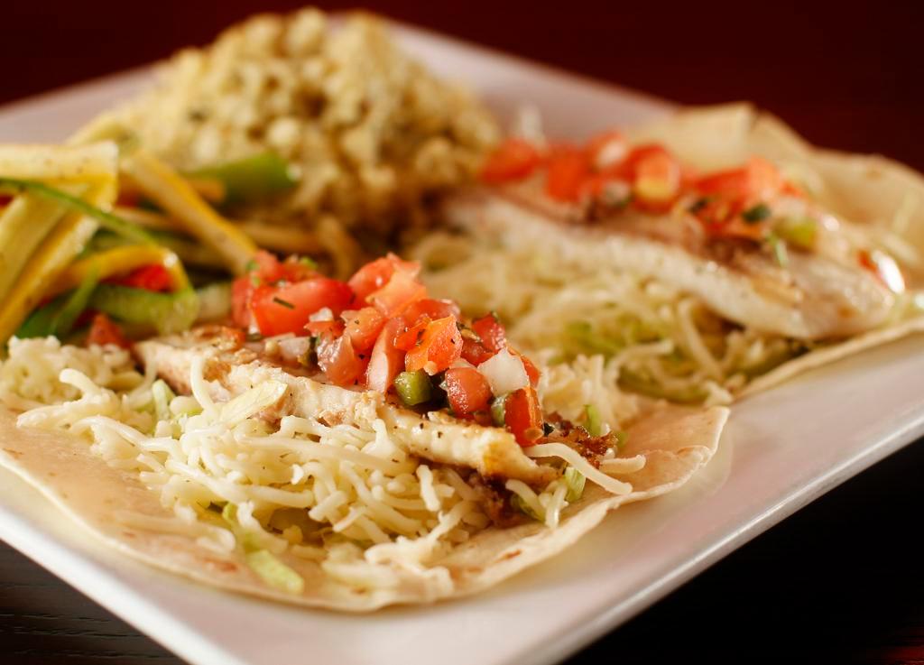 Fish Tacos (2 pc) · Flour tortillas filled with fish, roasted garlic sauce, lettuce, cheese, pico de gallo served with mixed vegetables and rice.