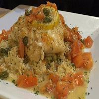 Herbs Stuffed Haddock · Tasty stuffed haddock with herbs and topped with a light lemon caper sauce over steamed cous...