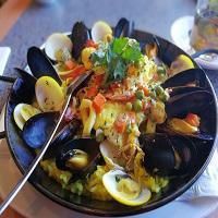 Catalan Seafood Paella · Traditional dish with white fish, shrimps, mussels, calamari, clams, veggies, herbs and lemo...