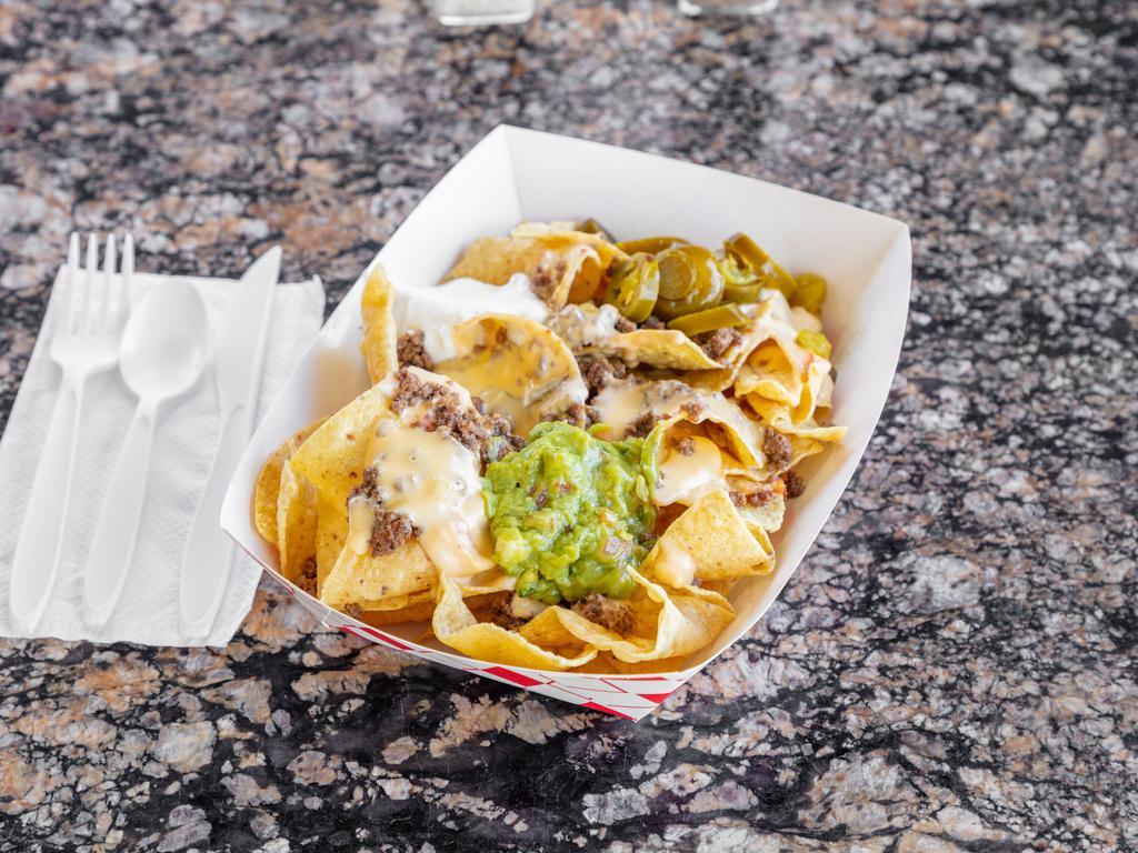 NACHOS · NACHO CHIPS- TOPPED WITH QUESO AND YOUR CHOICE OF MEAT. SIDE OF SOUR CREAM, GUACAMOLE AND JALAPEÑOS.