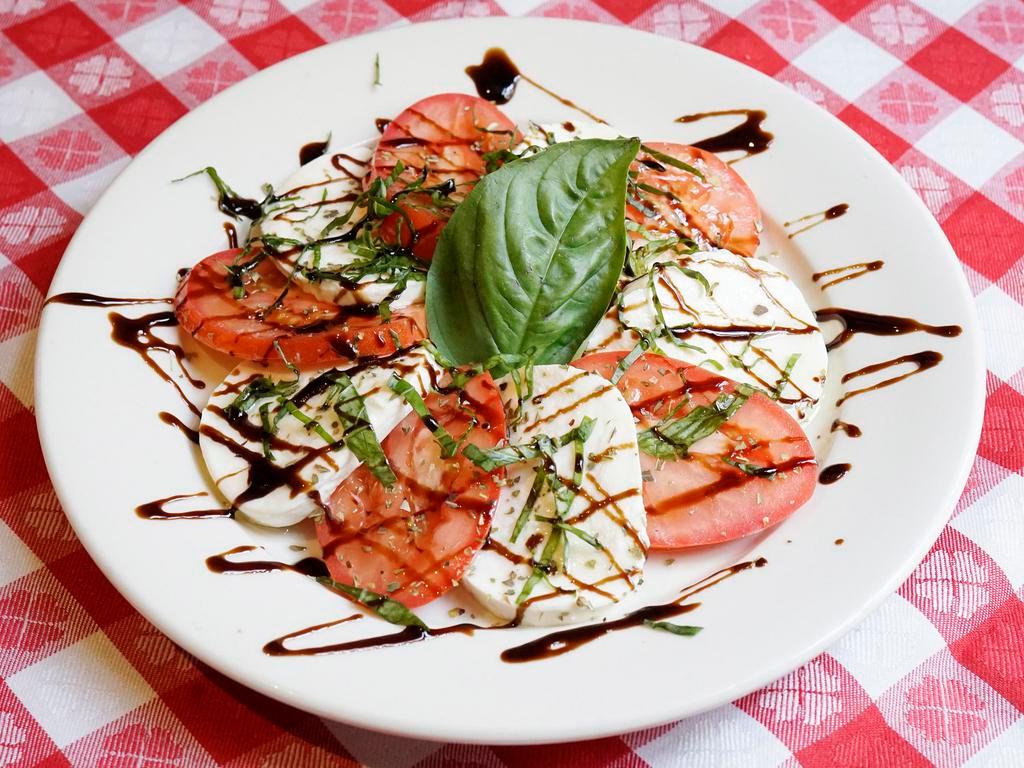 Insalata Caprese · Slices of fresh mozzarella, Roma tomatoes, and fresh basil drizzled with extra virgin olive oil and oregano.