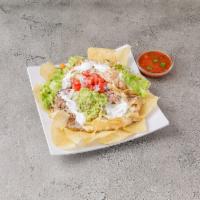 Nachos Supreme · creamy cheese sauce, ground beef, shredded chicken and refried beans. Topped with shredded l...