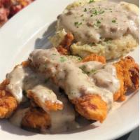 Chicken Fried Chicken · Mo’s crispy chicken tenders, topped with sausage gravy & paired with garlic mashed potatoes.