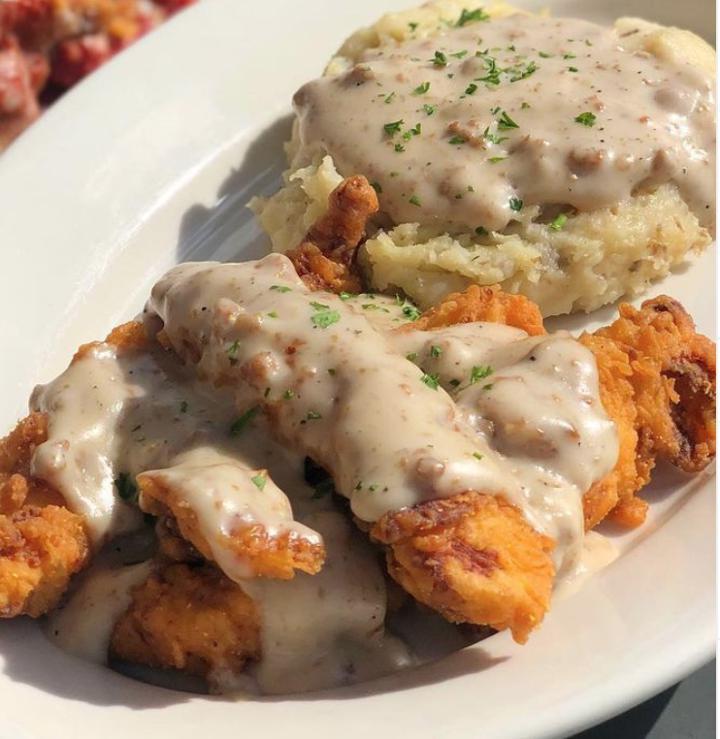 Chicken Fried Chicken · Mo’s crispy chicken tenders, topped with sausage gravy & paired with garlic mashed potatoes.
