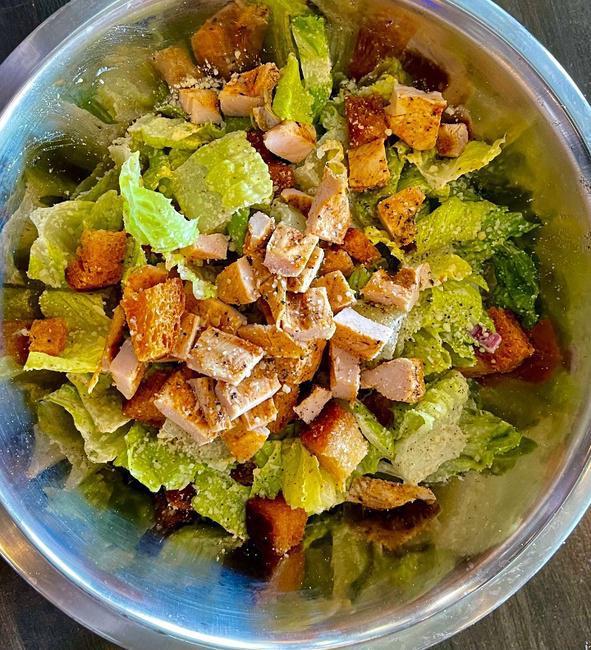 *GRILLED CHICKEN CAESAR. · Chopped romaine, house-made croutons, diced red onions, shaved parmesan, grilled chicken breast. tossed in House-made Caesar dressing.
