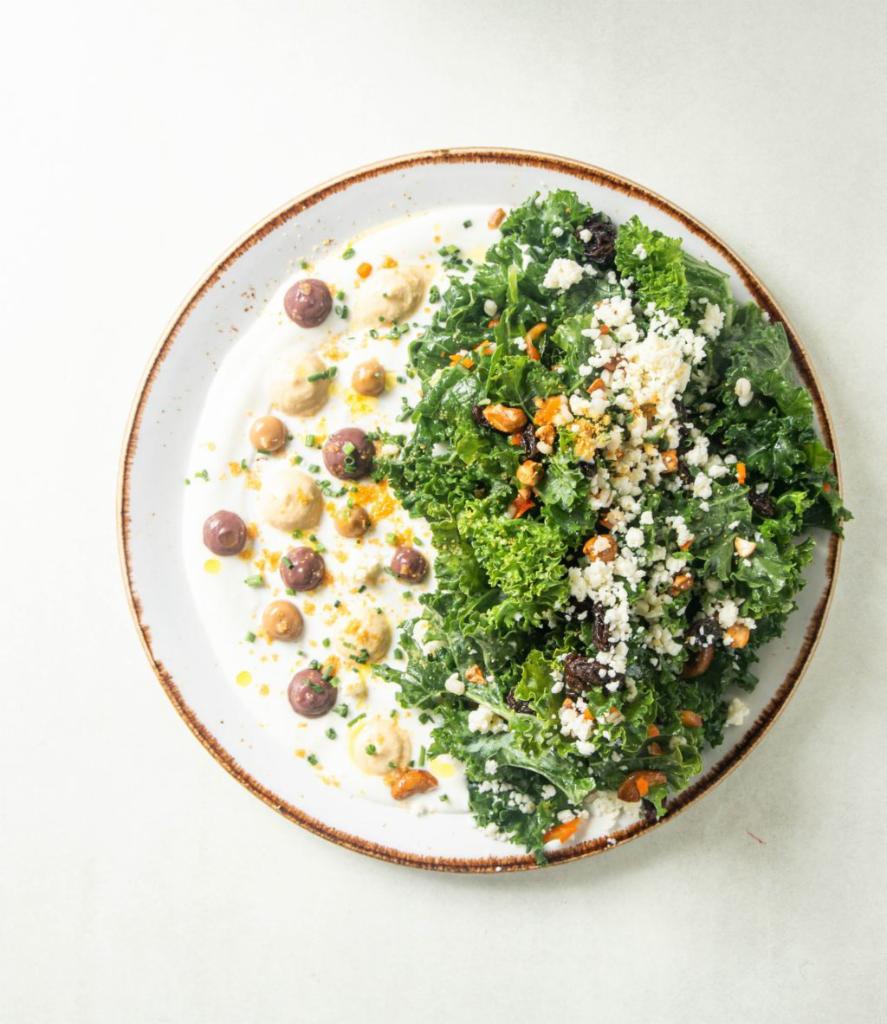 Mediterranean Kale Salad · Yuzu yogurt, olive puree, garlic puree, hummus, barley, raisins, cashews, cotija, veggie medley, chives, powdered croutons