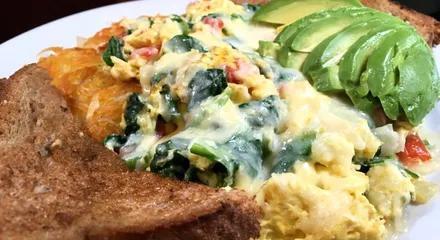 California Scramble · Onions, peppers, tomatoes and spinach, scrambled with eggs, over home fries, topped with Jack cheese and sliced avocado. Made with 3 large eggs, served with freshly grated hash browns or home fries and choice of toast.