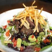 Carne Asada Salad · Fire grilled skirt steak, iceberg lettuce, tomato, avocado, jack cheese, black beans, tortil...