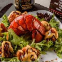 Rockin Lobster · Tempura lobster tail tossed in our headbanger sauce and served on a bed of spring mix. Toppe...