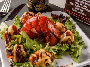 Rockin Lobster · Tempura lobster tail tossed in our headbanger sauce and served on a bed of spring mix. Topped with eel sauce and sprinkled with sesame seeds.
