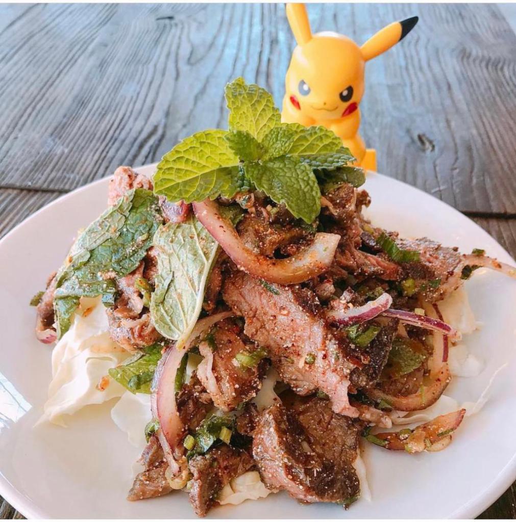 Crying Tiger Salad · Sliced steak, red onions, cilantro, mint, rice powder, herbs, and chili tossed in lime sauce. *Contains raw or undercooked food.