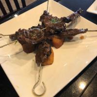 Anticuchos · Grilled beef heart made with Peruvian spices and served with half boiled and fried potato an...