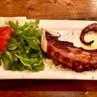 Pulpo al grill  · Grilled octopus marinated in olive oil,garlic,parsley and lemon and served with fried cassav...