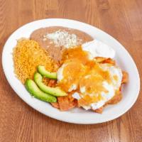 Chilaquiles Rojos · Crispy tortilla chips with red sauce. Two sunny side up eggs on top. side of rice, beans, ch...