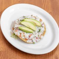 Tostada de Ceviche · Fish marinated with lime juice, jalapeno, red onion, carrots and topped with avocado slices.