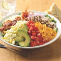 Market Cobb Salad · Our house salad mix blended with a creamy sun-dried tomato dressing and topped with ham, bac...