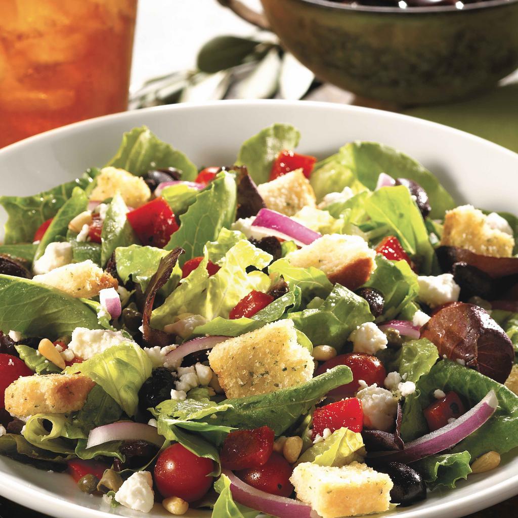 Greek Salad · Romaine lettuce, roasted peppers, red onions, grape tomatoes, Kalamata olives, capers, feta, toasted almonds, Greek vinaigrette and Parmesan croutons. Features fresh, hand-cut lettuce and vegetables.