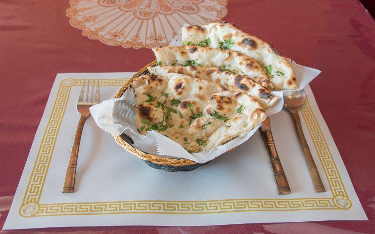 Garlic Naan  · Leavened bread touched with fresh shredded garlic and herbs then baked in our Clay Oven. 