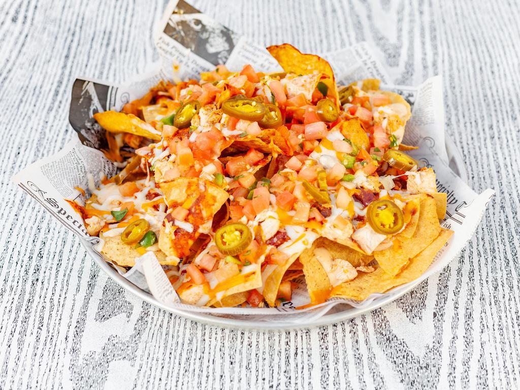 Nachos · Fresh corn tortilla chips loaded with our house chili, queso, cheddar, and mozzarella cheese. Topped with pico de gallo and fresh jalapenos. Served with salsa and sour cream. Add guacamole for an additional charge.