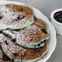 Blueberry Pancakes · Buttermilk pancakes infused with plump blueberries and dusted with powdered sugar. Served wi...